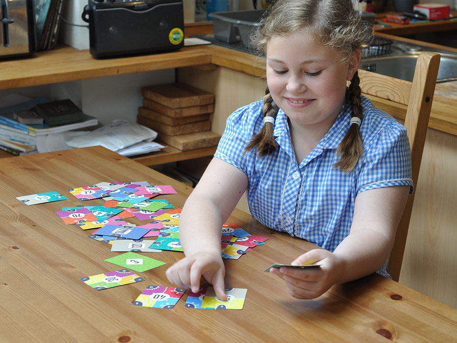 Child at home with times tables cards