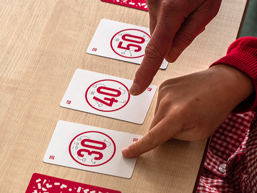 Child counting in 10s with maths cards